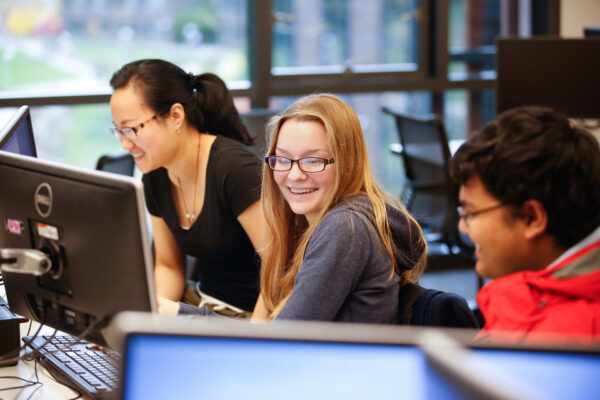 students working together at computers in a classroom