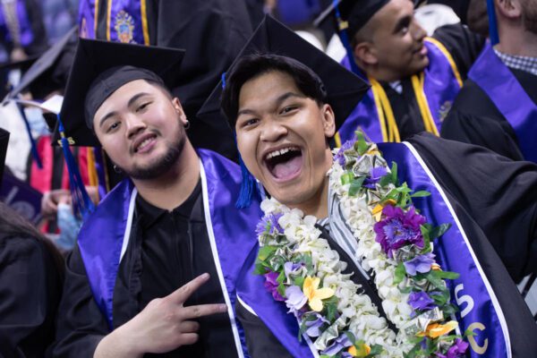 Two people in graduation gowns and caps.