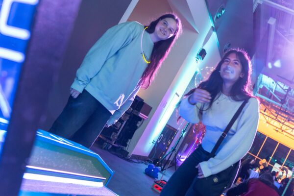 Two girls playing an arcade game.