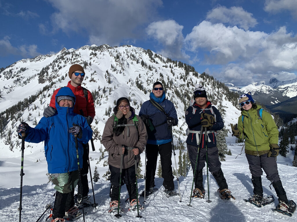 Students on snowshoes posing in front of a snowy mountain at Mount Baker