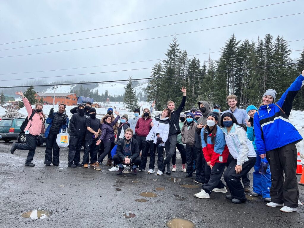 Large group of students pose in the parking lot at Snoqualmie Pass