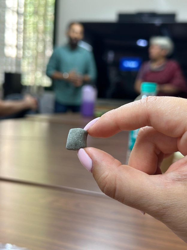 A piece of Gud Gum being held up in a conference room