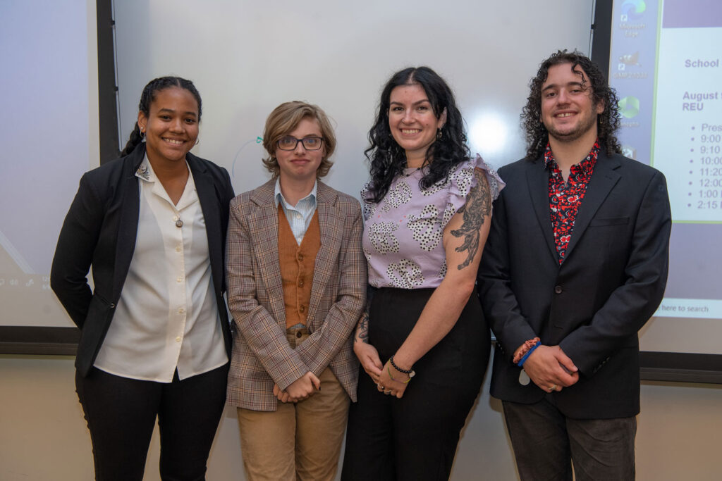 A group of four people pose for a photo.