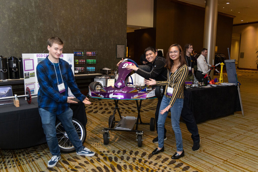 A group of people pose for a photo with a go-kart.