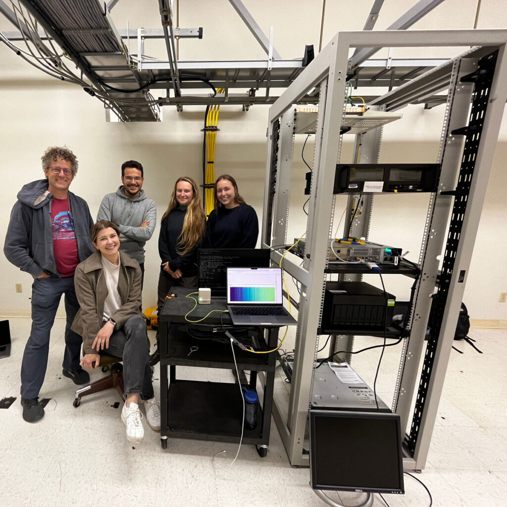 A group of people pose for a photo next to some equipment.