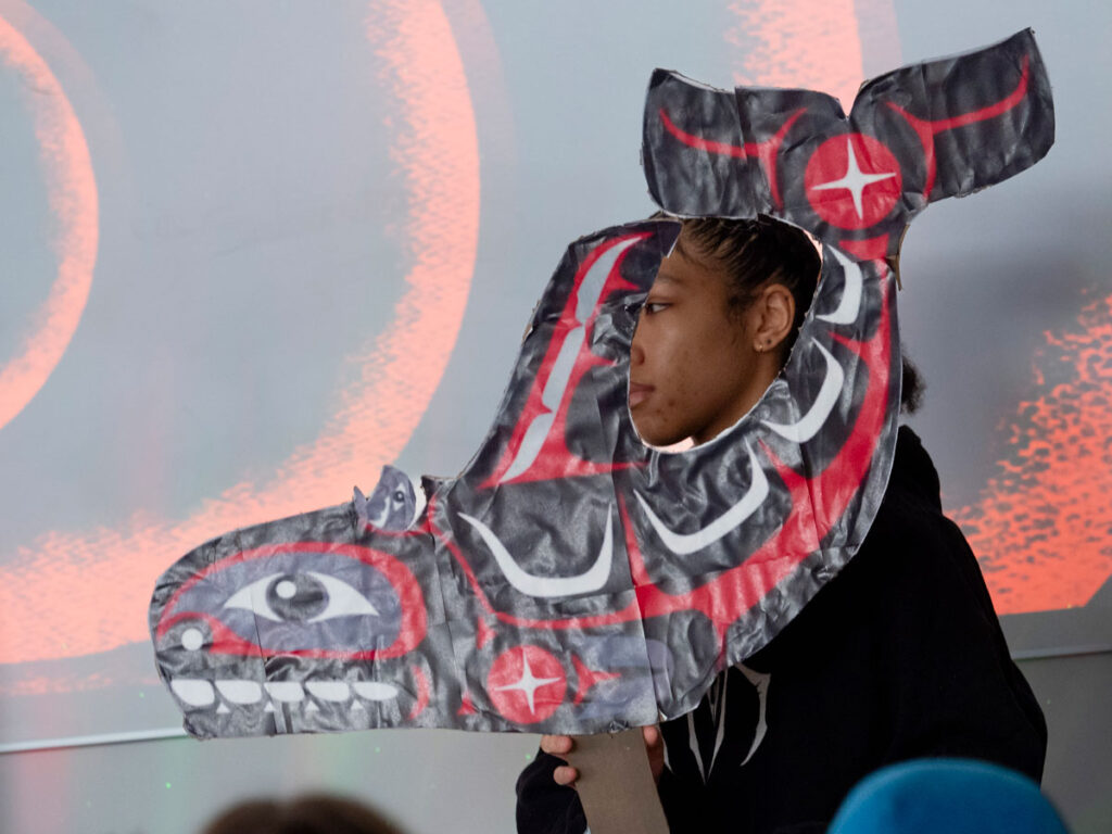 A person holding an orca cutout. 