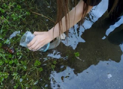 Kira Reiber collecting her sample at Cottage Lake