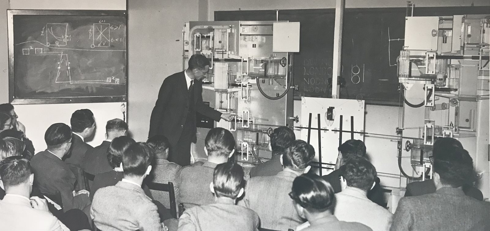 Meade demonstrating the two-country machine to his seminar in 1952